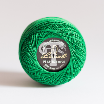 Novelo de linha verde em algodão mercerizado com rótulo preto circular