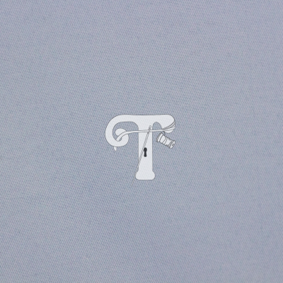 Logótipo branco da letra T com elementos de costura sobre fundo azul claro texturizado