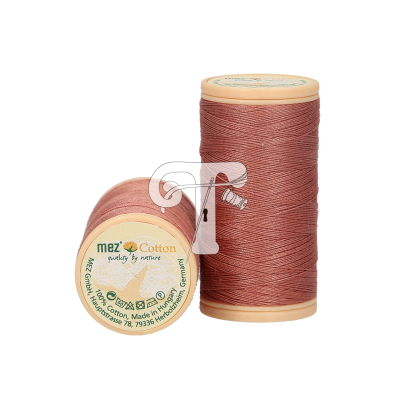 Dois carretéis de linha de algodão rosa velho com etiquetas verdes sobre fundo branco