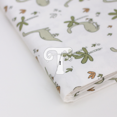 tecido branco estampado com desenhos de aves verdes e folhas castanhas