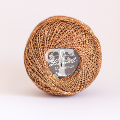 Novelo de linha metalizada bronze da marca Liz Ló com rótulo preto