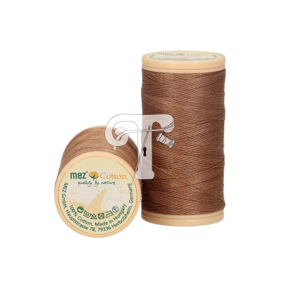 Duas bobinas de linha castanha com rótulo 'mez Cotton quality by nature'.