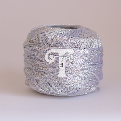 Novelo de fio prateado brilhante sobre superfície clara