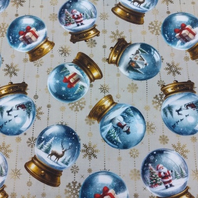 Tecido com padrão natalício de bolas de neve douradas e imagens festivas em fundo creme.