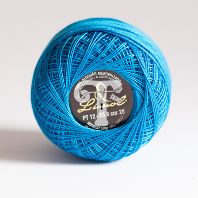 Rolo de linha de algodão mercerizado azul com etiqueta preta atrás