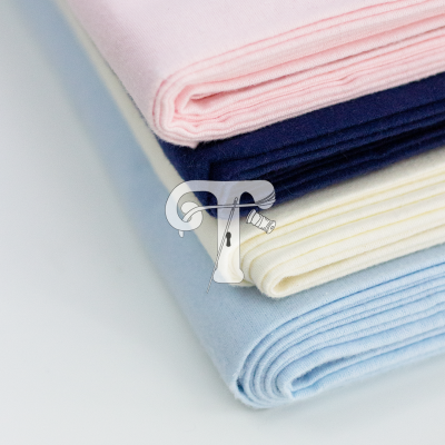 Quatro tecidos dobrados em rosa claro, azul escuro, creme e azul claro, textura de algodão