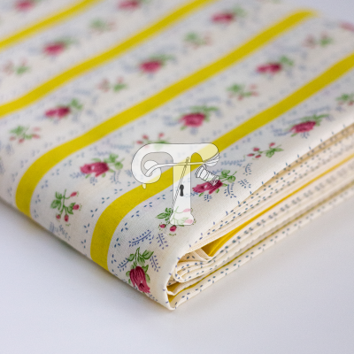 Tecido dobrado com flores cor-de-rosa e faixas amarelas sobre fundo branco