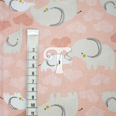 Tecido rosa com padrão de elefantes brancos e fita métrica.