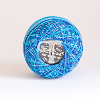 Rolo de fio azul com etiqueta central preta e branca