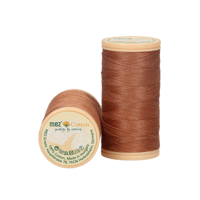 Dois carretéis de linha castanha com etiquetas em plástico creme