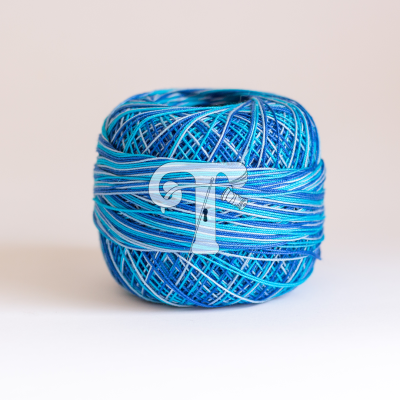 Novelo de fio azul com etiqueta com letra T