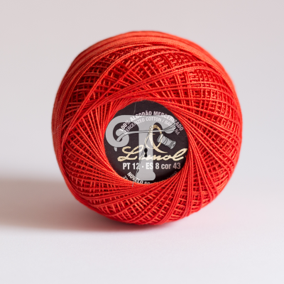 Novelo de linha de algodão vermelho com etiqueta preta ao centro