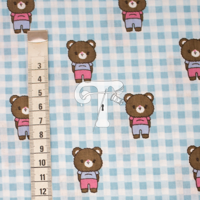 Tecido azul claro xadrez com ursinhos castanhos vestidos e fita métrica