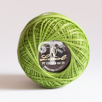 Novelo de linha de algodão verde claro com etiqueta preta redonda no centro