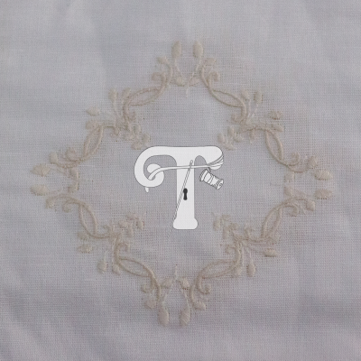 Tecido branco com bordado floral em relevo formando padrão circular