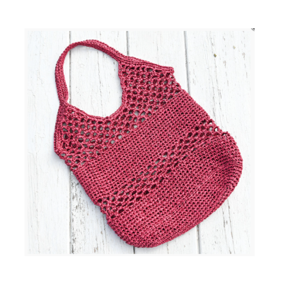 Saco croché vermelho escuro sobre superfície de madeira branca