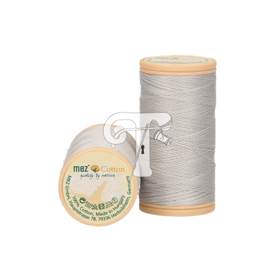 Dois rolos de linha de costura cinza claro com carretel bege, um em pé e outro deitado com rótulo da marca Mez Cotton