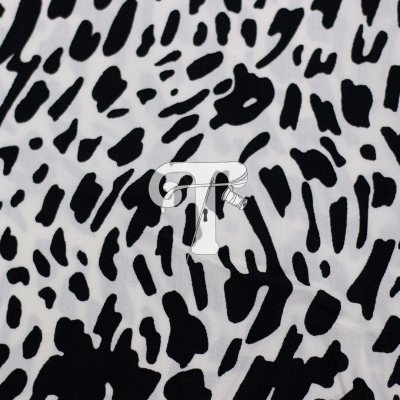 Tecido branco com padrão animal preto, manchas irregulares similares a pele de leopardo