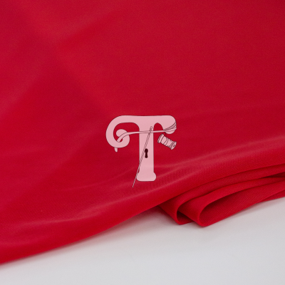 Tecido vermelho liso dobrado sobre superfície branca