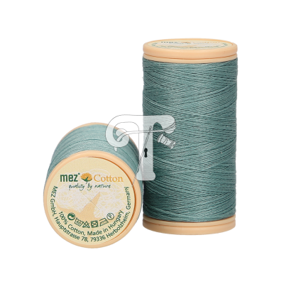 Dois carretéis de linha de algodão azul-esverdeado com bobinas bege