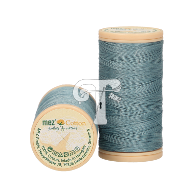 Dois carretéis de linha de algodão azul claro com base e topo bege, um deles está deitado mostrando o rótulo.