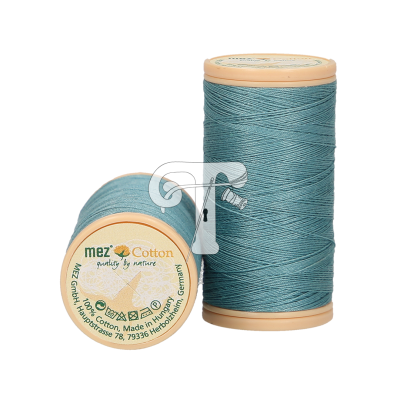 Dois carretéis de linha azul esverdeada com rótulos redondos em bege