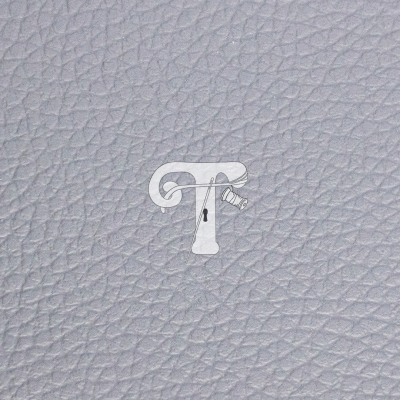 Superfície em pele sintética cinza claro com textura granulada e marca d'água com letras T e F