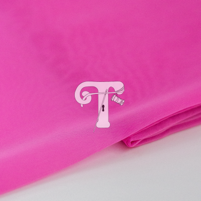 Tecido rosa vibrante dobrado sobre superfície branca