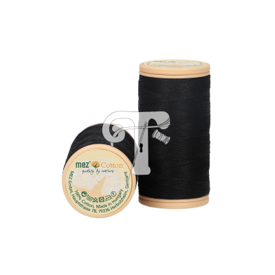 Dois carretéis de linha preta com bases bege e etiquetas com texto 'mez Cotton purely by nature'.