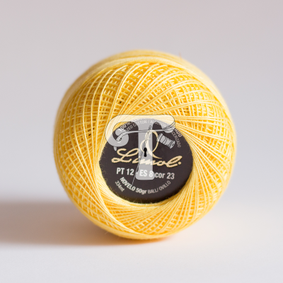 Novelo de linha de algodão amarelo com etiqueta preta central