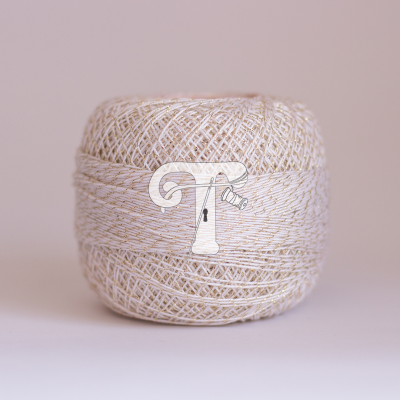 Novelo de fio branco com linhas douradas entrelaçadas sobre superfície clara