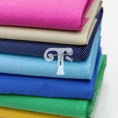 Pilha de tecidos coloridos com padrão de pequenos pontos brancos