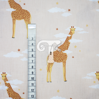Tecido bege com estampa de girafas, nuvens e estrelas e régua de medição
