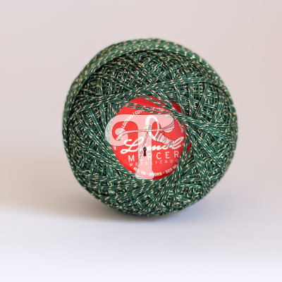 Novelo de linha verde metalizada com etiqueta vermelha e texto branco