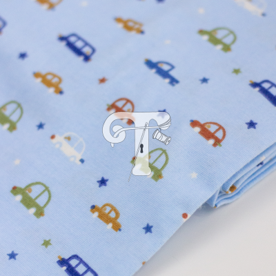 tecido azul claro com padrão de pequenos carros coloridos e estrelas