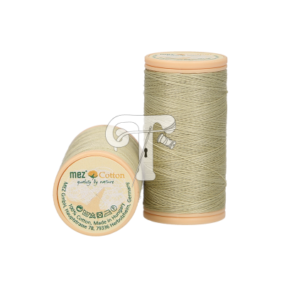 Dois carretéis de linha de algodão verde claro da marca mez com base bege e texto na base.