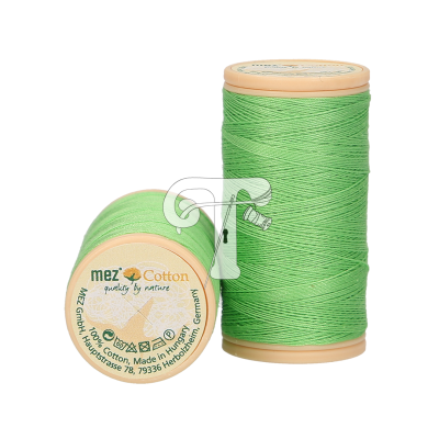 Dois carretéis de linha verde clara de algodão da marca mez com base bege