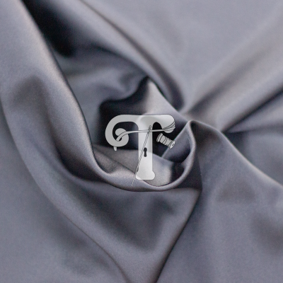 Tecido cinzento acetinado com dobra e logótipo branco letra T