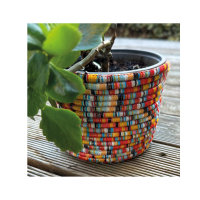 Vaso decorativo colorido com planta em deck de madeira