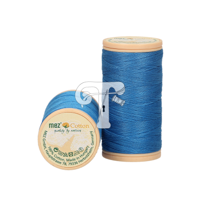 Dois carretéis de linha de algodão azul com rótulos 'mez Cotton purity by nature'