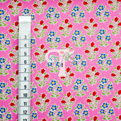 Tecido rosa com padrão floral colorido e fita métrica para escala