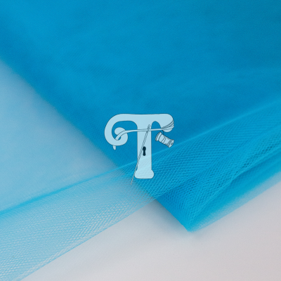 tecido tule azul turquesa dobrado em superfície branca