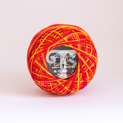 Bola de linha vermelha e amarela com etiqueta preta e branca