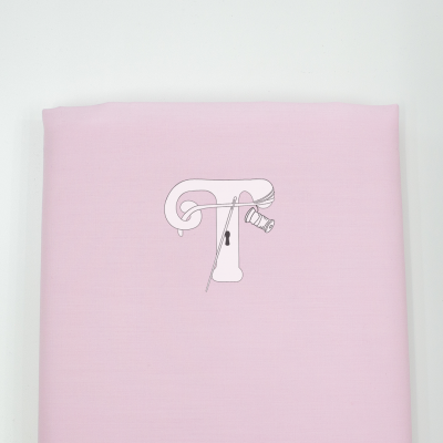 Tecido rosa com ilustração da letra T e ferramentas de costura