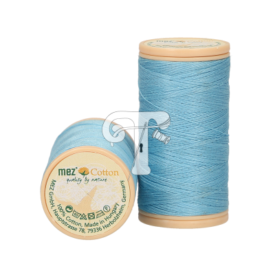 Dois carretéis de linha azul claro, um em pé e outro deitado mostrando etiqueta com texto