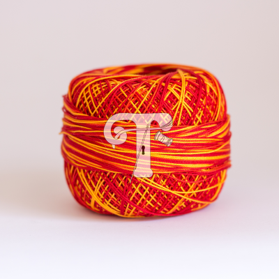 Novelo de fio vermelho e amarelo com padrão listrado em fundo claro