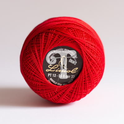 Novelo de linha vermelho com etiqueta preta no centro