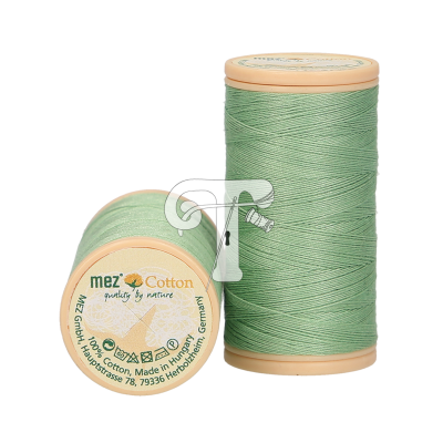 Dois carretéis de linha de algodão verde claro Mez Cotton com tampas bege e texto da marca