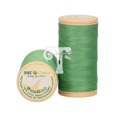 Dois carretéis de linha de algodão verde com etiqueta e texto visível