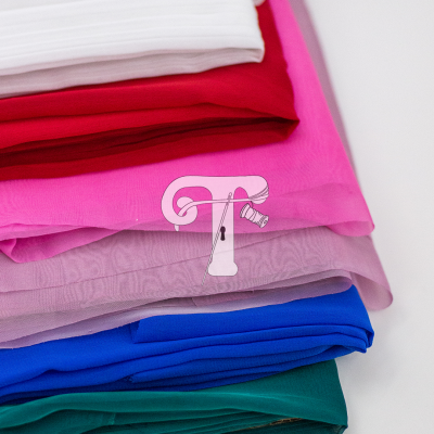 tecidos coloridos dobrados empilhados em superfície branca